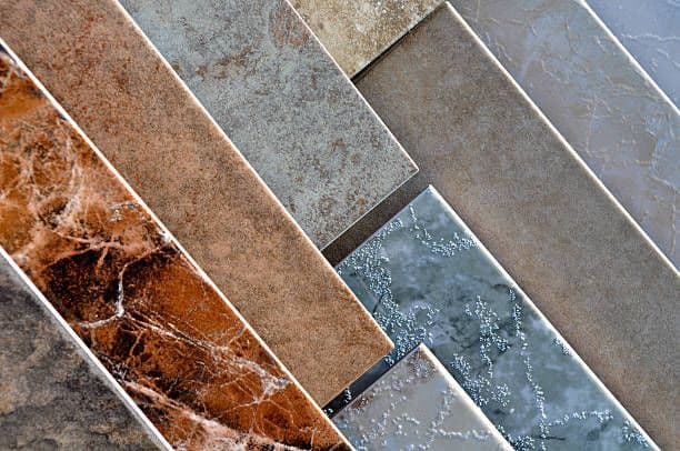 Tile samples arranged in diagonal pattern showing progression from warm rustic tones to cool gray finishes